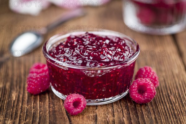 Homemade Raspberry Jam on an wooden table as detailed close-up shot, selective focus