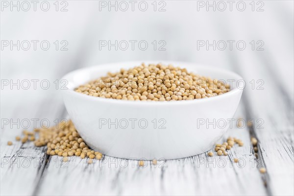 Seeds (Mustard) as high detailed close-up shot on a vintage wooden table (selective focus)