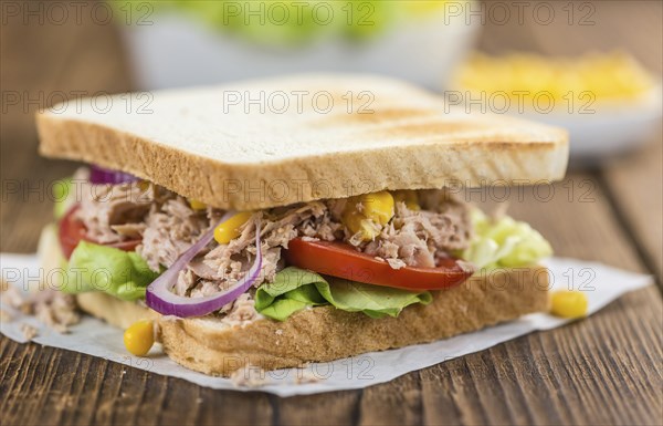 Homemade Tuna Sandwich (selective focus, close-up shot) on vintage wooden background