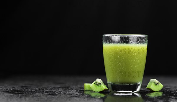 Some fresh homemade Kiwi Smoothies on a slate slab (close-up shot, selective focus)