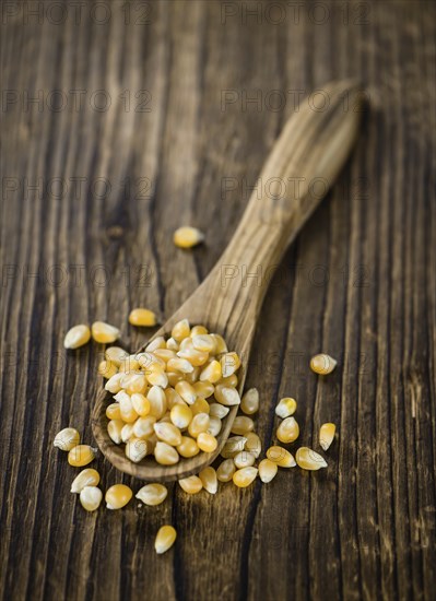 Portion of Corn (detailed close-up shot) on wooden background (selective focus)