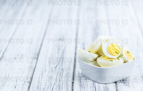 Wooden table with halved Eggs (selective focus, close-up shot)