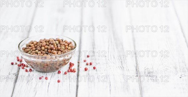 Preserved Pink Peppercorns on a vintage background as detailed close-up shot, selective focus