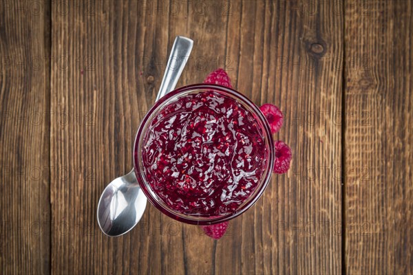 Homemade Raspberry Jam on an wooden table as detailed close-up shot, selective focus