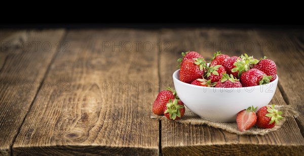 Strawberries on an old wooden table as detailed close-up shot, selective focus