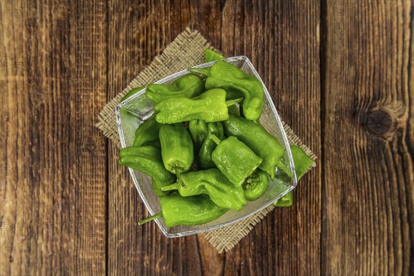 Raw Pimientos on rustic wooden background as close-up shot