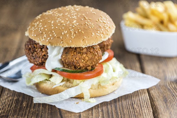 Wooden table with a homemade Falafel Burger (selective focus)