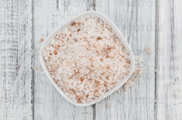 Himalayan Salt as high detailed close-up shot on a vintage wooden table (selective focus)