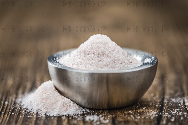 Himalayan Salt as high detailed close-up shot on a vintage wooden table (selective focus)