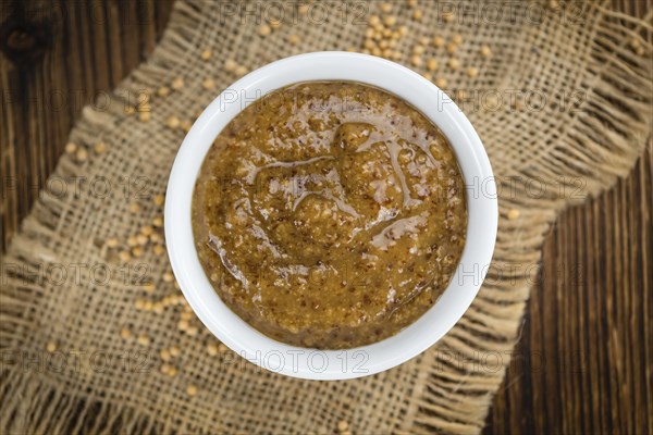 Homemade Sweet Mustard on an wooden table (selective focus) as detailed close-up shot