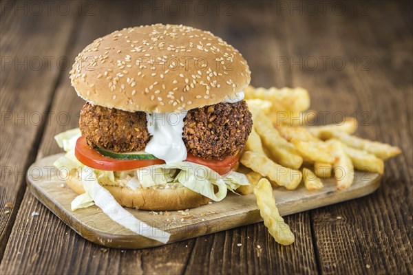 Homemade Falafel Burger (detailed close-up shot, selective focus) on a wooden table
