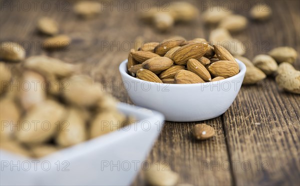 Almonds in shell (roasted and salted) on a vintage background (close-up shot)