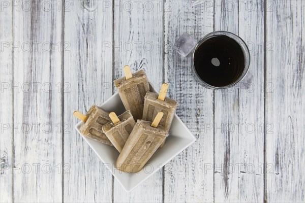 Some homemade Cola Popsicles (close-up shot, selective focus) on vintage background