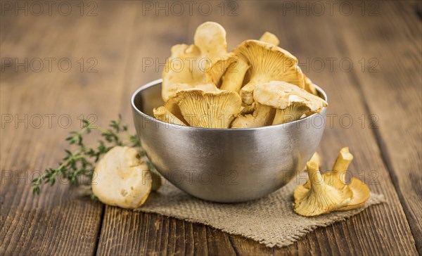 Chanterelles (freshly harvested) on an old wooden table as detailed close-up shot (selective focus)