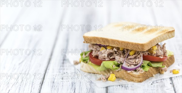 Homemade Tuna Sandwich (selective focus, close-up shot) on vintage wooden background