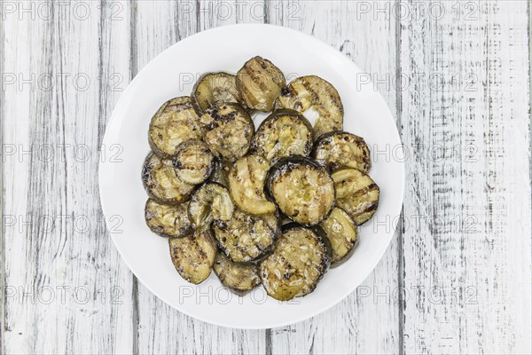Zucchinis (grilled) as high detailed close-up shot on a vintage wooden table (selective focus)