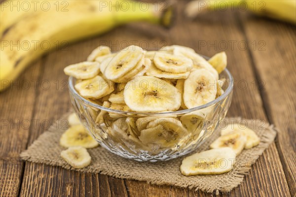 Fresh made Dried Banana Chips on an old and rustic wooden table, selective focus, close-up shot