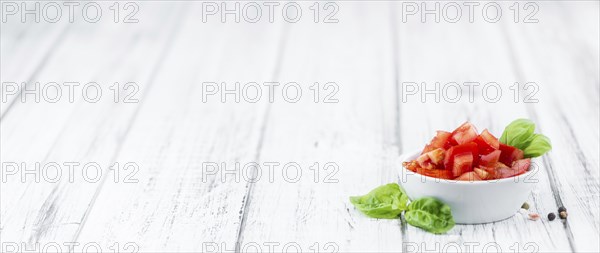 Cutted Tomatoes on an old wooden table as detailed close-up shot (selective focus)