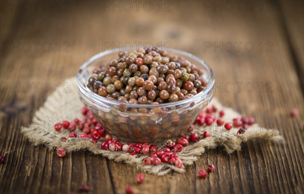 Preserved Pink Peppercorns on a vintage background as detailed close-up shot, selective focus