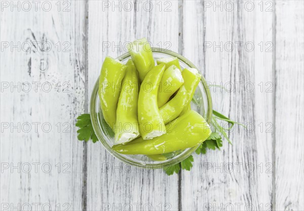 Pimientos (filled with cream cheese) on rustic wooden background (close-up shot)