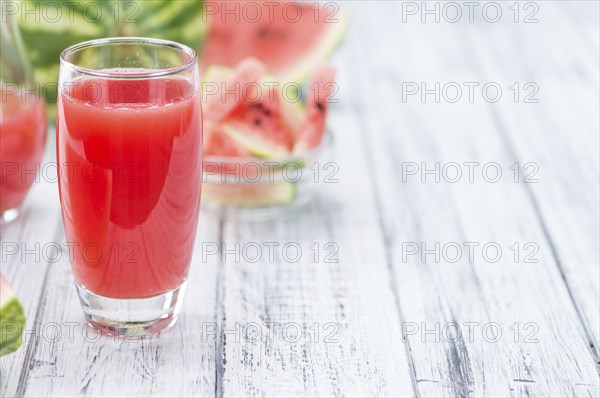 Homemade Watermelon Smoothie on an wooden table (selective focus) as detailed close-up shot