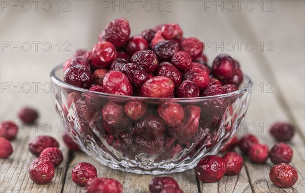 Dried Cranberries on an old wooden table (selective focus)