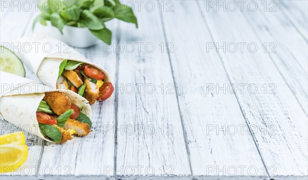 Portion of Chicken Wraps (selective focus) on an old wooden table