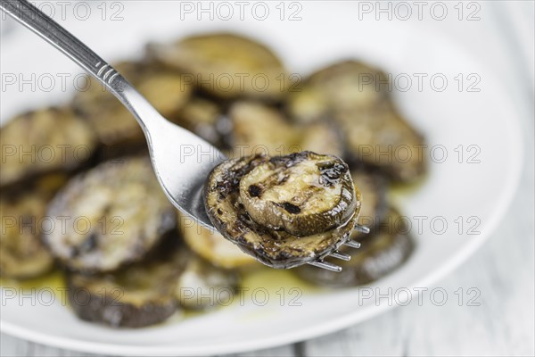 Fresh made Zucchinis (grilled) on an old and rustic wooden table (selective focus, close-up shot)