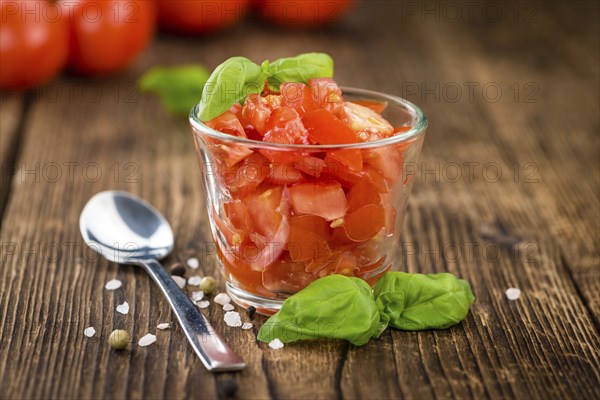 Cutted Tomatoes on an old wooden table as detailed close-up shot (selective focus)