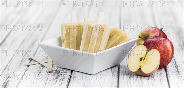 Apple Popsicles on an old wooden table (close-up shot, selective focus)