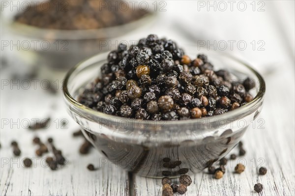 Black Peppercorns preserved on wooden background, selective focus, close-up shot