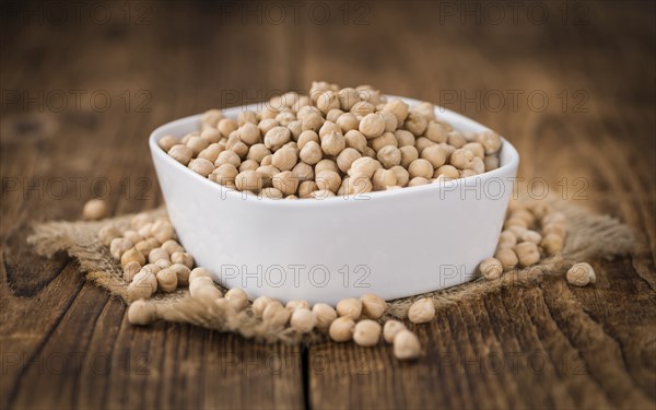 Dried Chickpeas as high detailed close-up shot on a vintage wooden table, selective focus