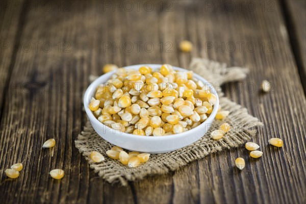 Dried Corn (detailed close-up shot, selective focus) on vintage wooden background