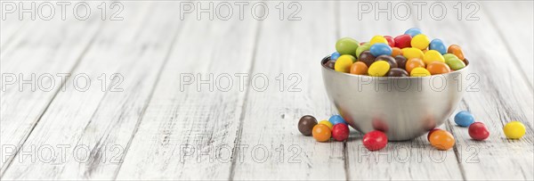 Fresh made Cocolate coated Peanuts on a vintage background (close-up shot)