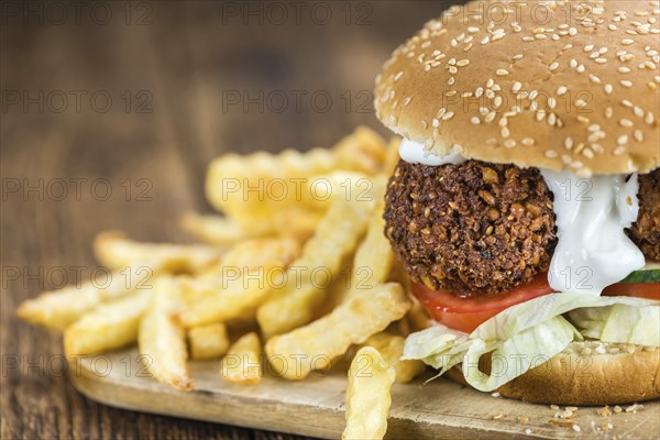 Fresh made Falafel Burger (close-up shot, selective focus) on wooden background