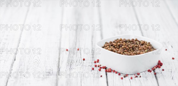 Portion of fresh preserved Pink Peppercorns close-up shot, selective focus