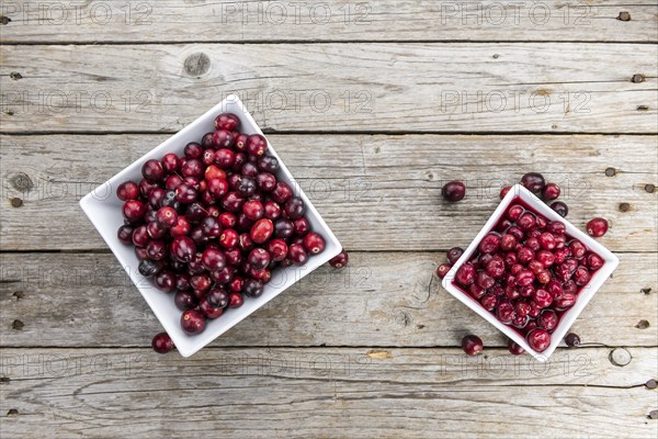 Vintage wooden table with Cranberries (preserved) (selective focus, close-up shot)