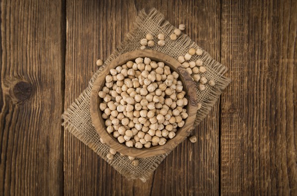 Dried Chickpeas as high detailed close-up shot on a vintage wooden table, selective focus