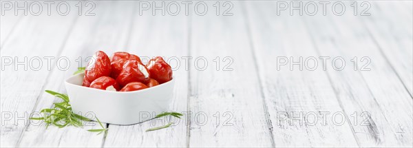 Filled Pimientos on an old wooden table as detailed close-up shot (selective focus)
