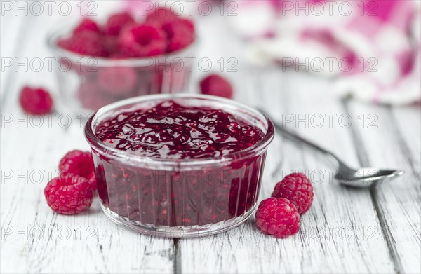 Homemade Raspberry Jam on an wooden table as detailed close-up shot, selective focus