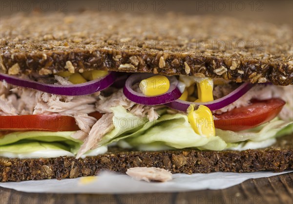Old wooden table with Tuna sandwich (on wholemeal bread, selective focus)