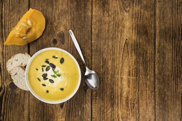 Homemade Pumpkin Soup (selective focus) on rustic background as close-up shot