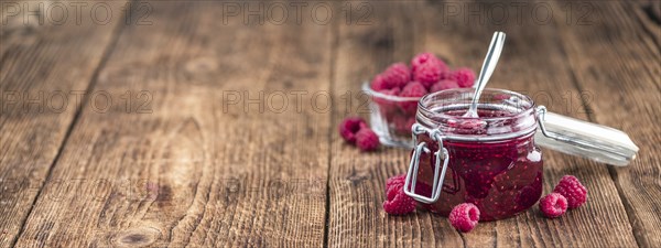 Fresh made Raspberry Jam on an old and rustic wooden table, selective focus, close-up shot