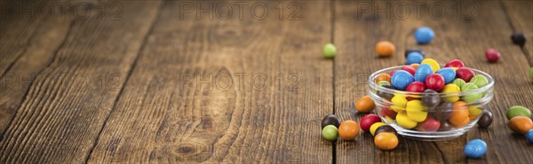 Cocolate coated Peanuts on an old wooden table as detailed close-up shot (selective focus)