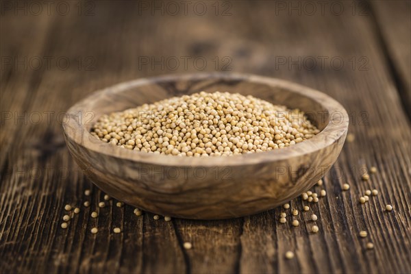 Mustard Seeds on rustic wooden background (close-up shot)