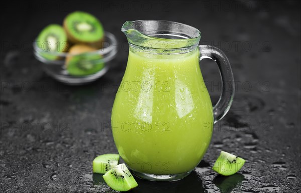 Some fresh homemade Kiwi Smoothies on a slate slab (close-up shot, selective focus)
