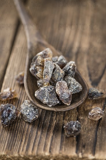 Wooden table with brown Rock Candy (close-up shot, selective focus)