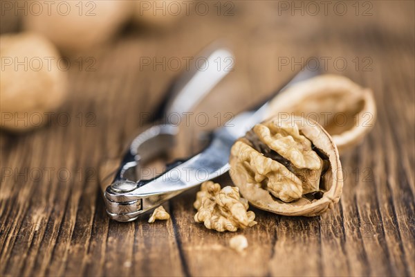 Walnuts on rustic wooden background (close-up shot)