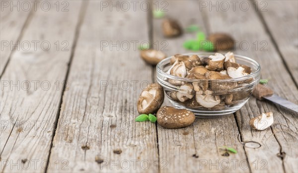 Shiitake mushrooms on an old wooden table as detailed close-up shot, selective focus