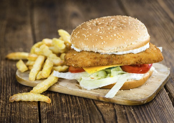 Fish Burger (selective focus, close-up shot) on wooden background